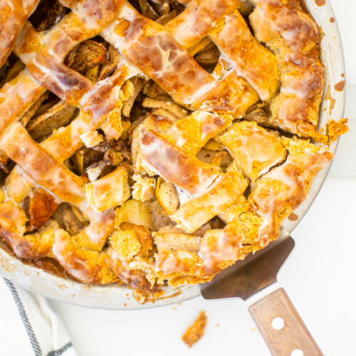 vanilla bean apple pie with a slice cut out with a pie server in the pie pan.