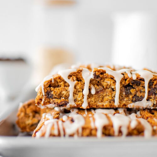 glazed oatmeal raisin biscotti on a baking sheet on a white marble counter.