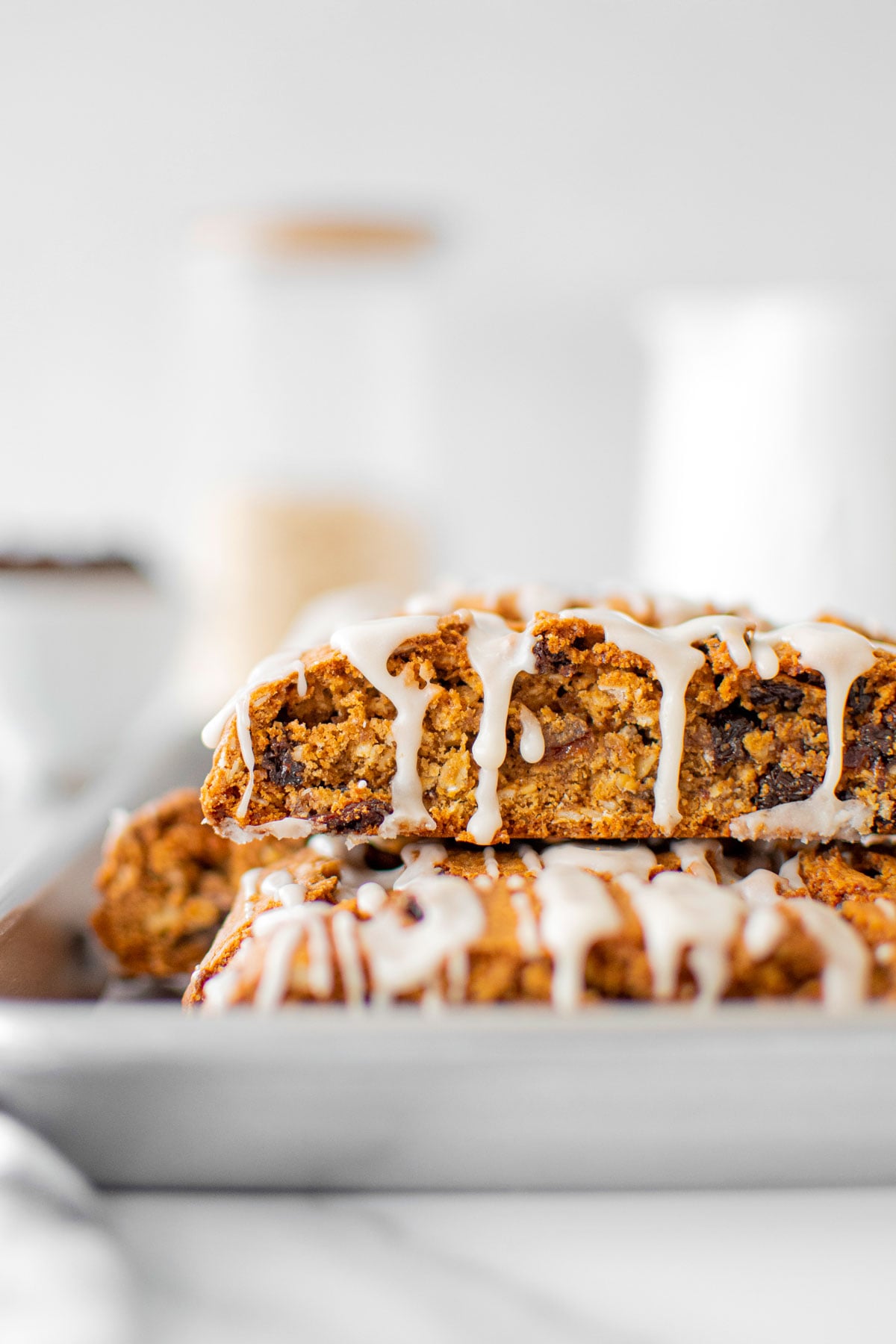 glazed oatmeal raisin biscotti on a baking sheet on a white marble counter.