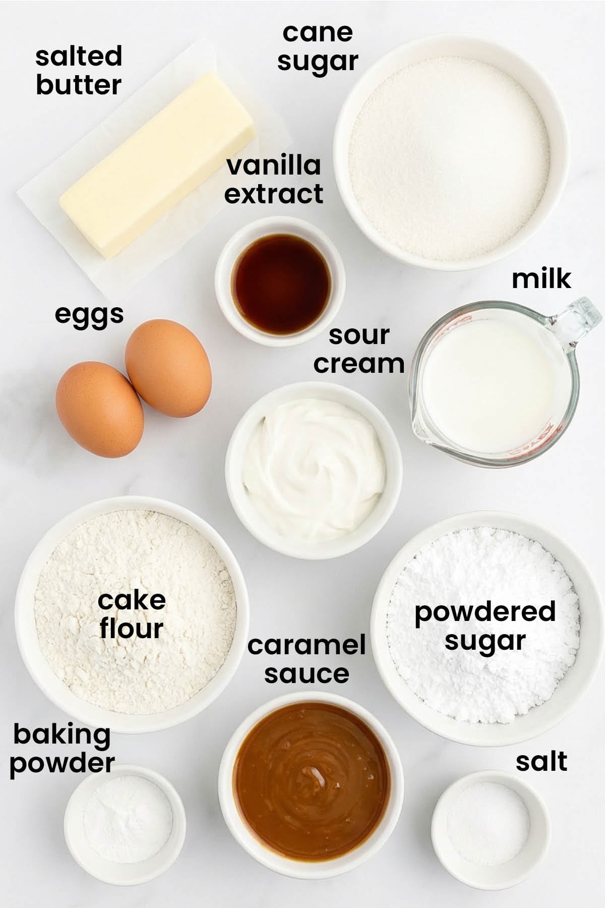individual ingredients for salted caramel cake laid out against a white background.
