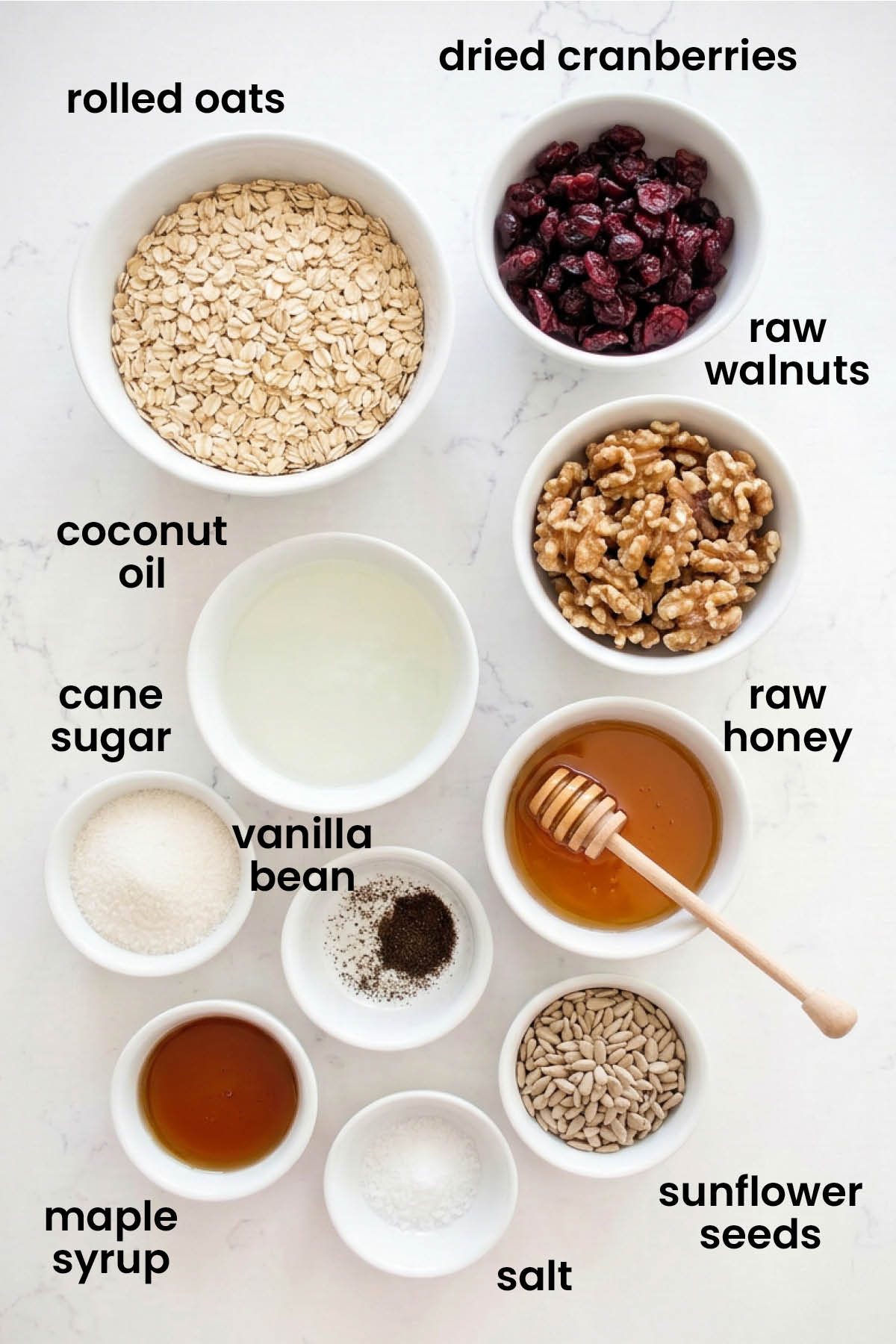 individual ingredients for homemade vanilla granola with cranberries laid out against a white background.