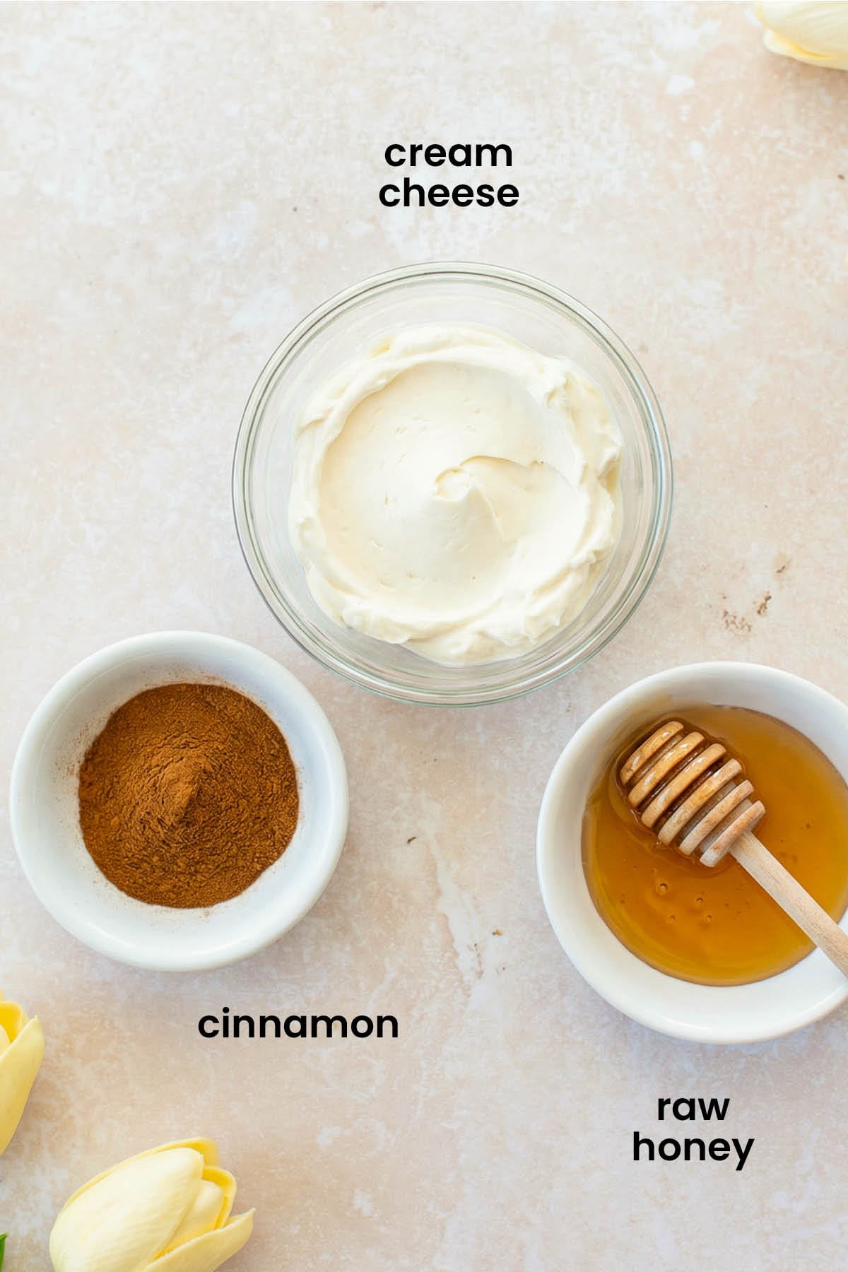 individual ingredients for cinnamon honey cream cheese spread laid out against a white background.