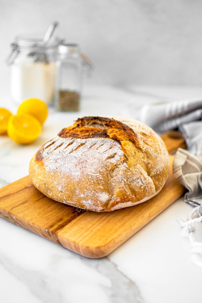 lemon rosemary sourdough bread on a wood cutting board.