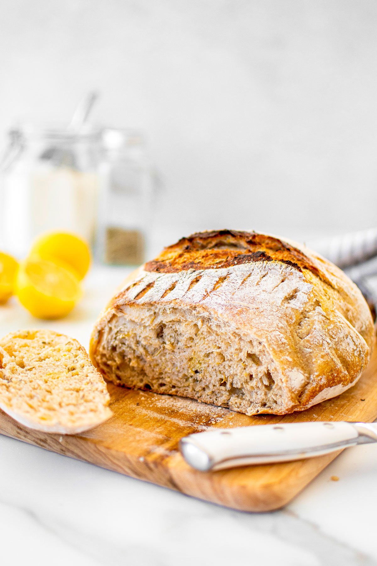 lemon rosemary sourdough bread on a wood cutting board.