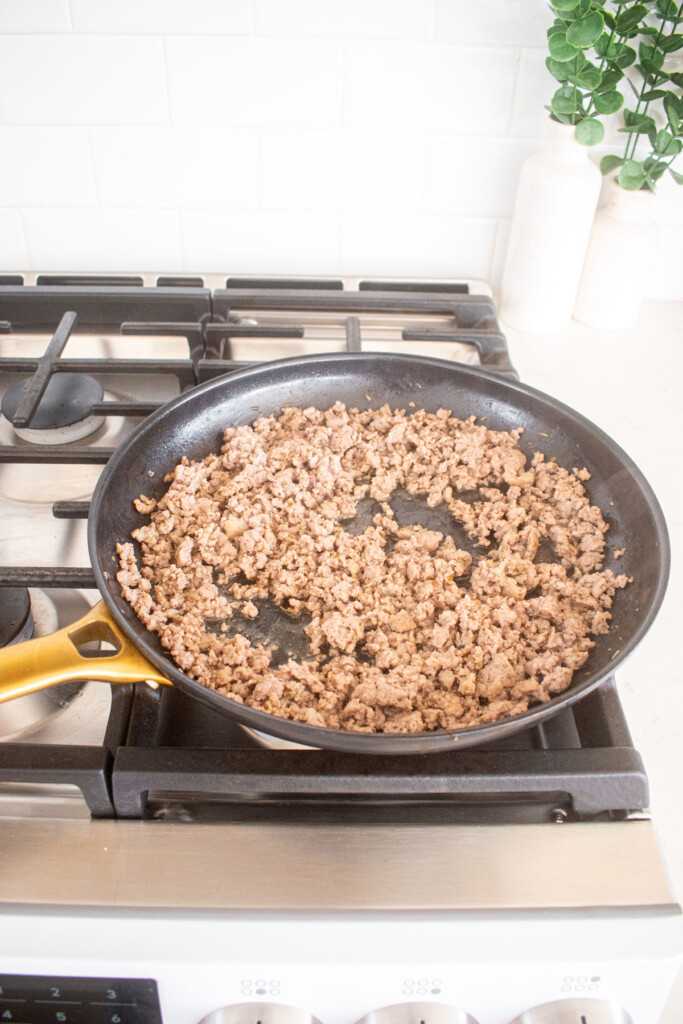 cooked ground beef in a large skillet on the stovetop.