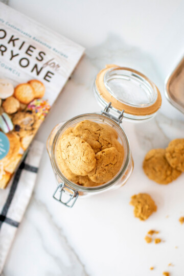 cookie jar of peanut butter dog cookies on a white marble countertop.