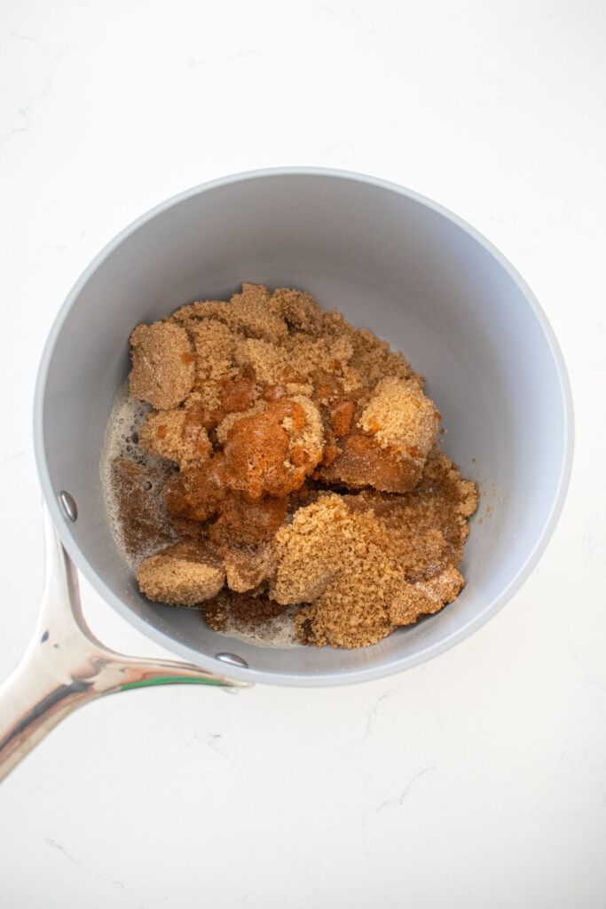 brown butter and brown sugar in a small pot on a white marble counter.