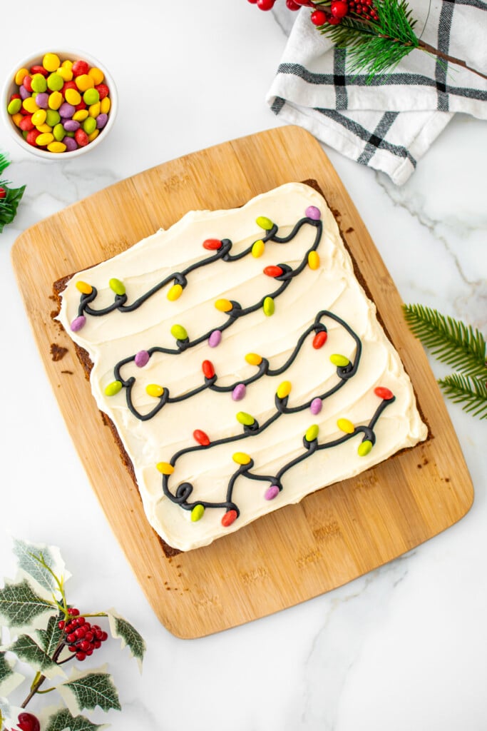 christmas lights gingerbread snack cake on a wood cutting board on a marble counter.