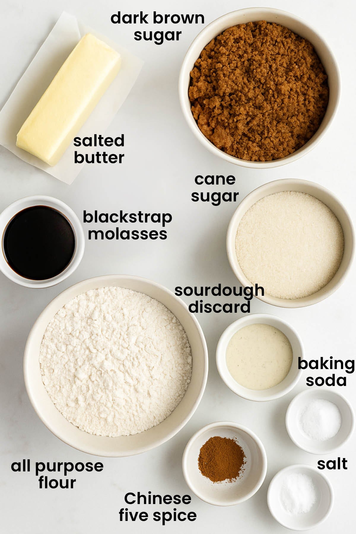 individual ingredients for eggless sourdough molasses cookies laid out against a white background.