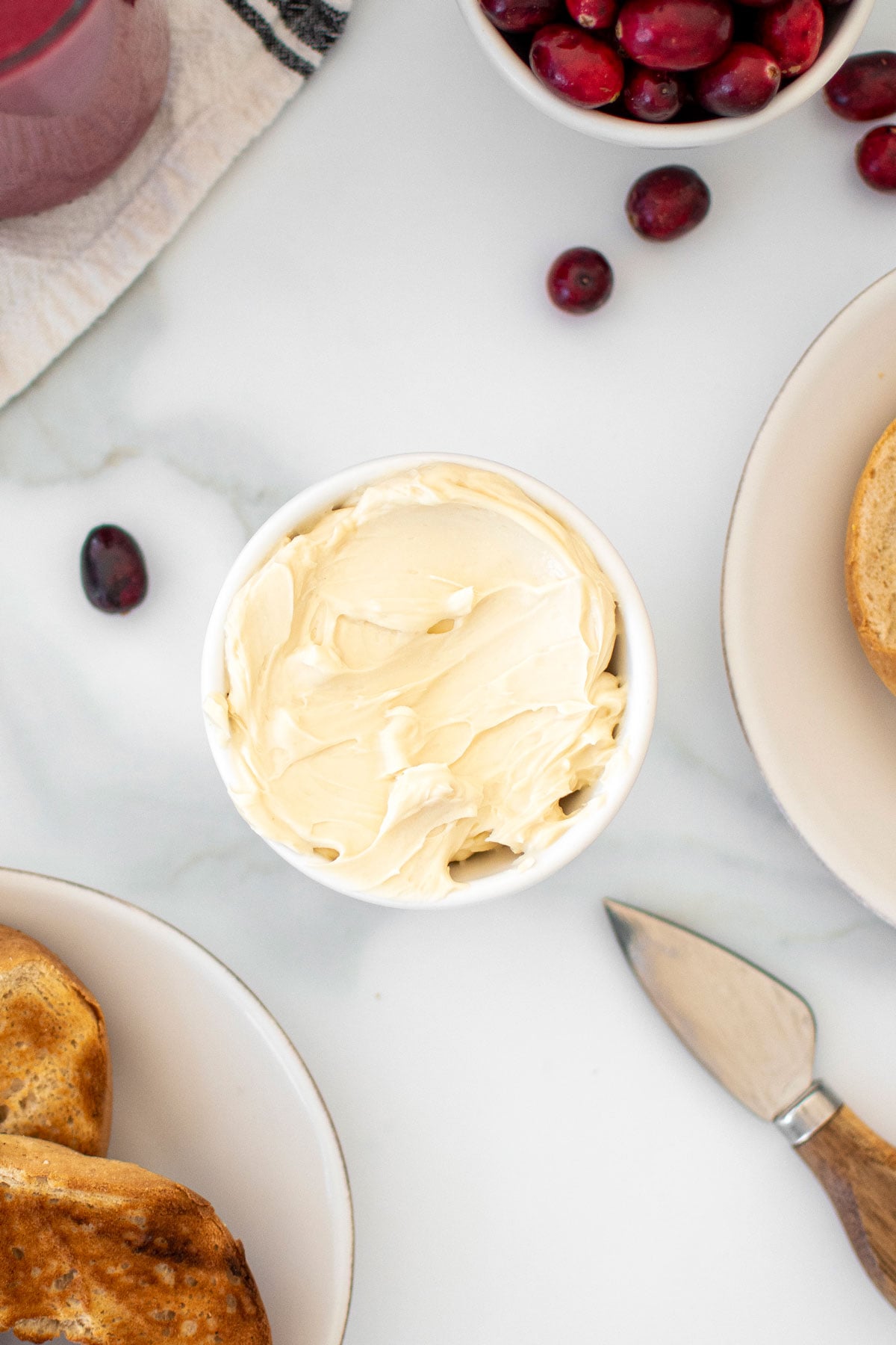 maple cream cheese spread in a small white bowl on a marble counter.