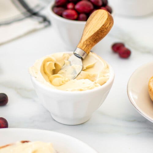 maple cream cheese spread in a small white bowl on a marble counter.