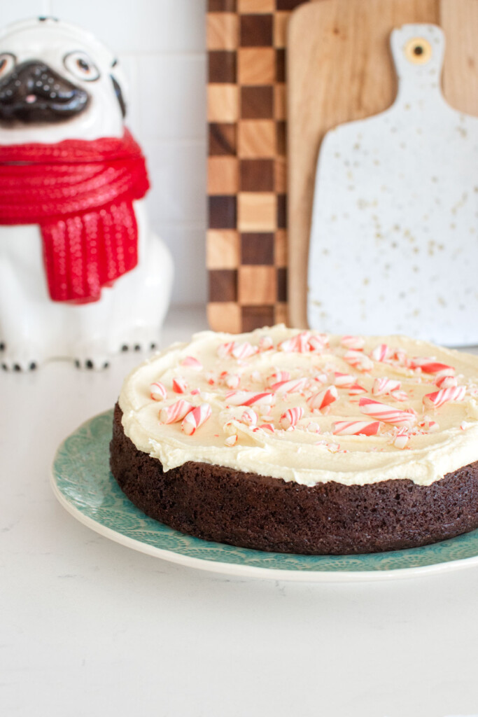 peppermint bark snack cake on a green cake plate on a white kitchen counter.