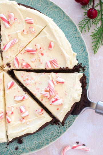 peppermint bark snack cake cut into slices on a green cake plate.