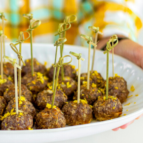 plate of rosemary meatball bites with toothpicks in them.