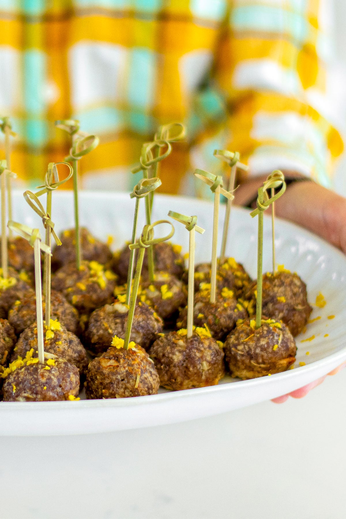 plate of rosemary meatball bites with toothpicks in them.