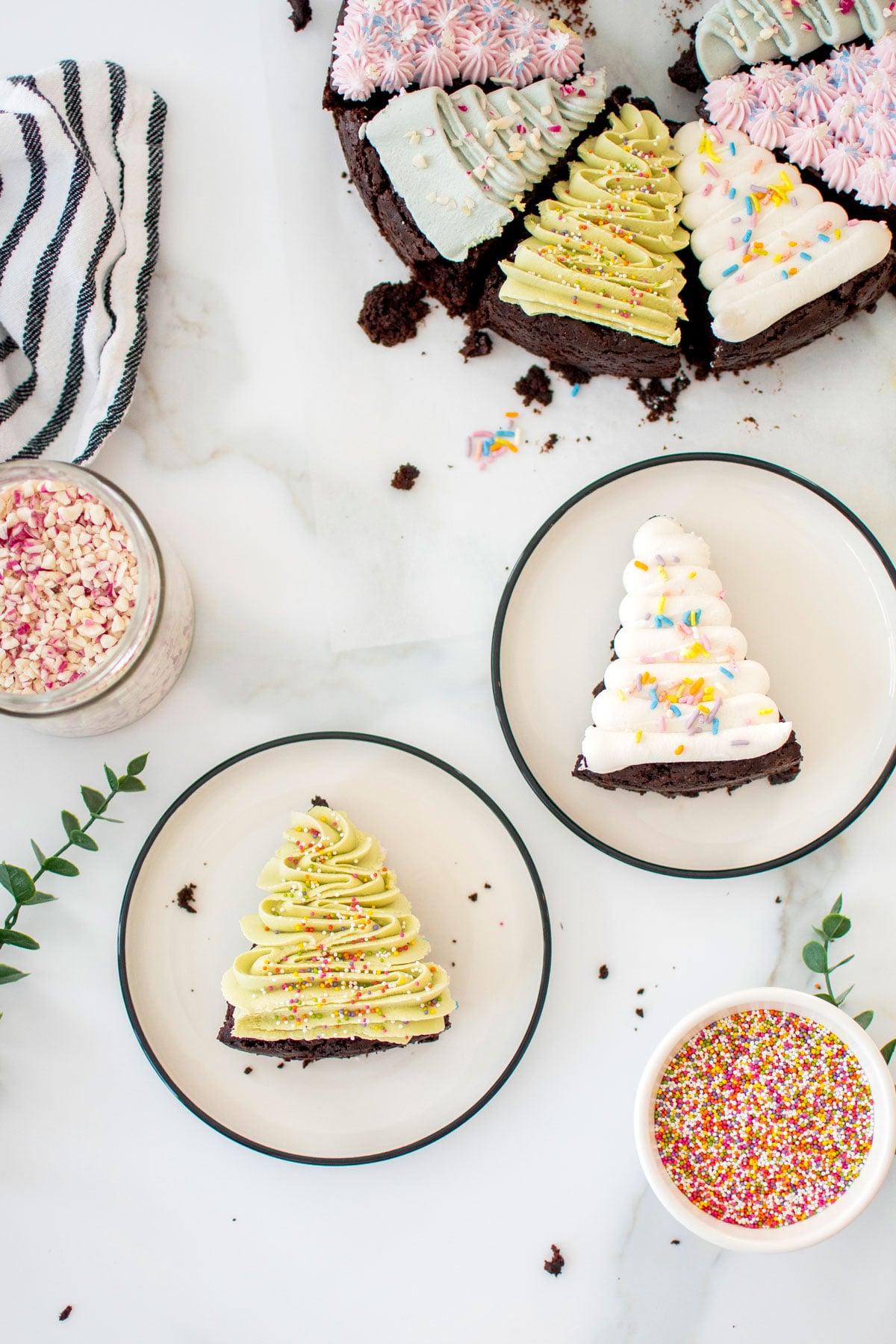 vegan christmas tree brownies on a plate on a white marble counter.