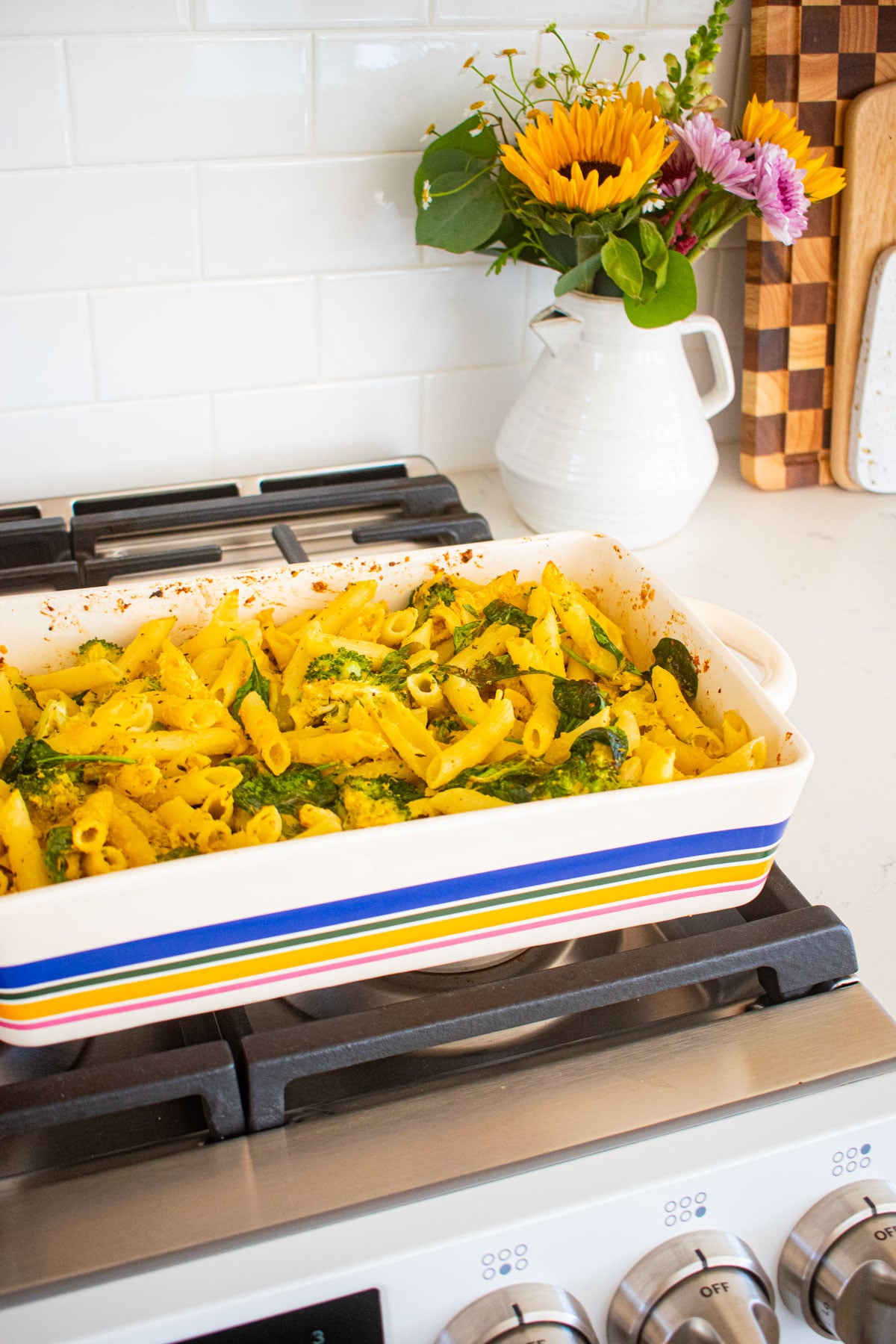 baked butter lemon pasta mixed together in a striped baking dish on the kitchen counter.