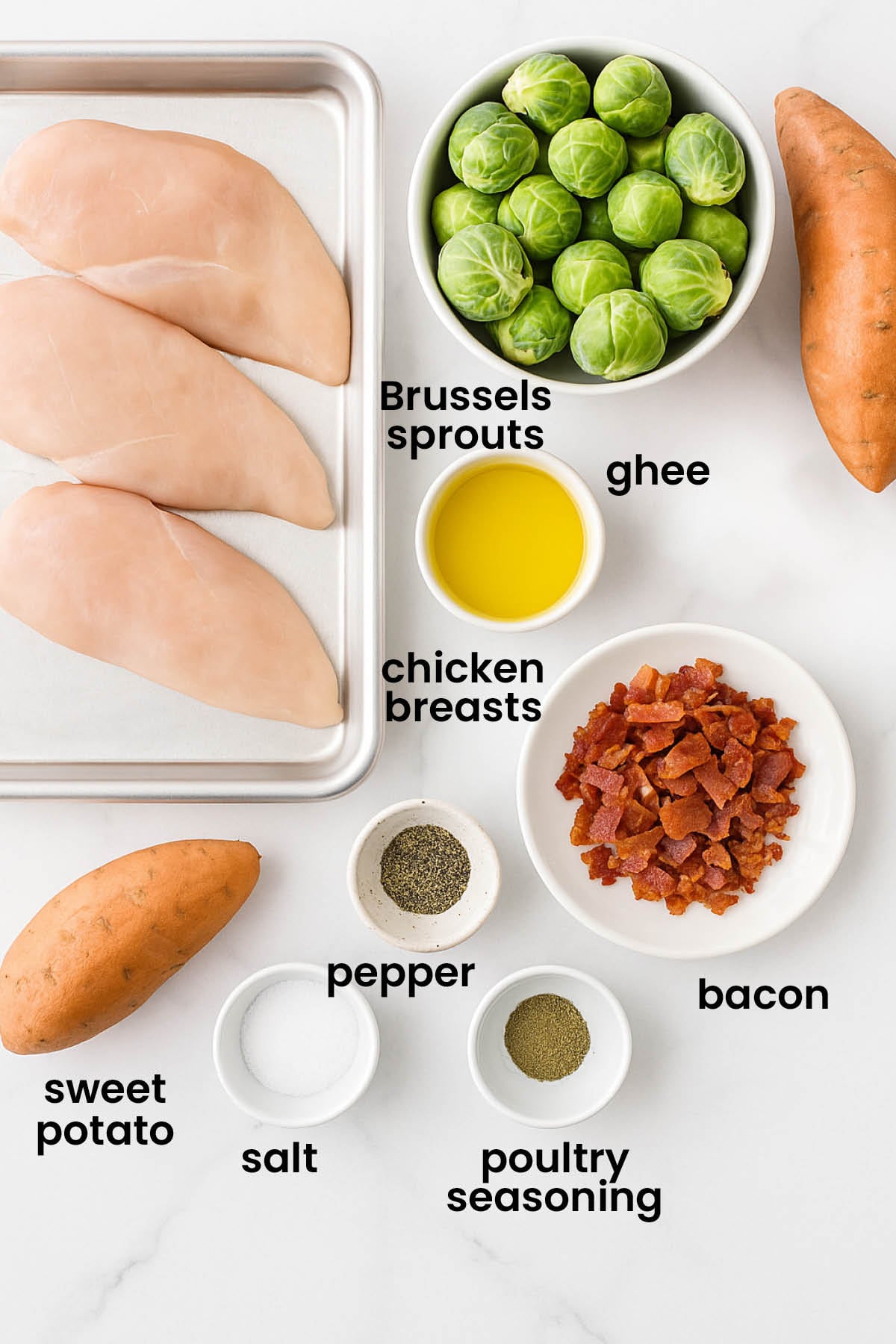 individual ingredients for chicken and Brussels sheet pan dinner with bacon laid out against a white background.