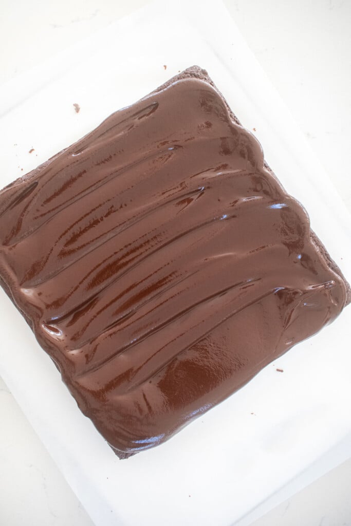 eggless chocolate ganache brownies on a white marble counter.