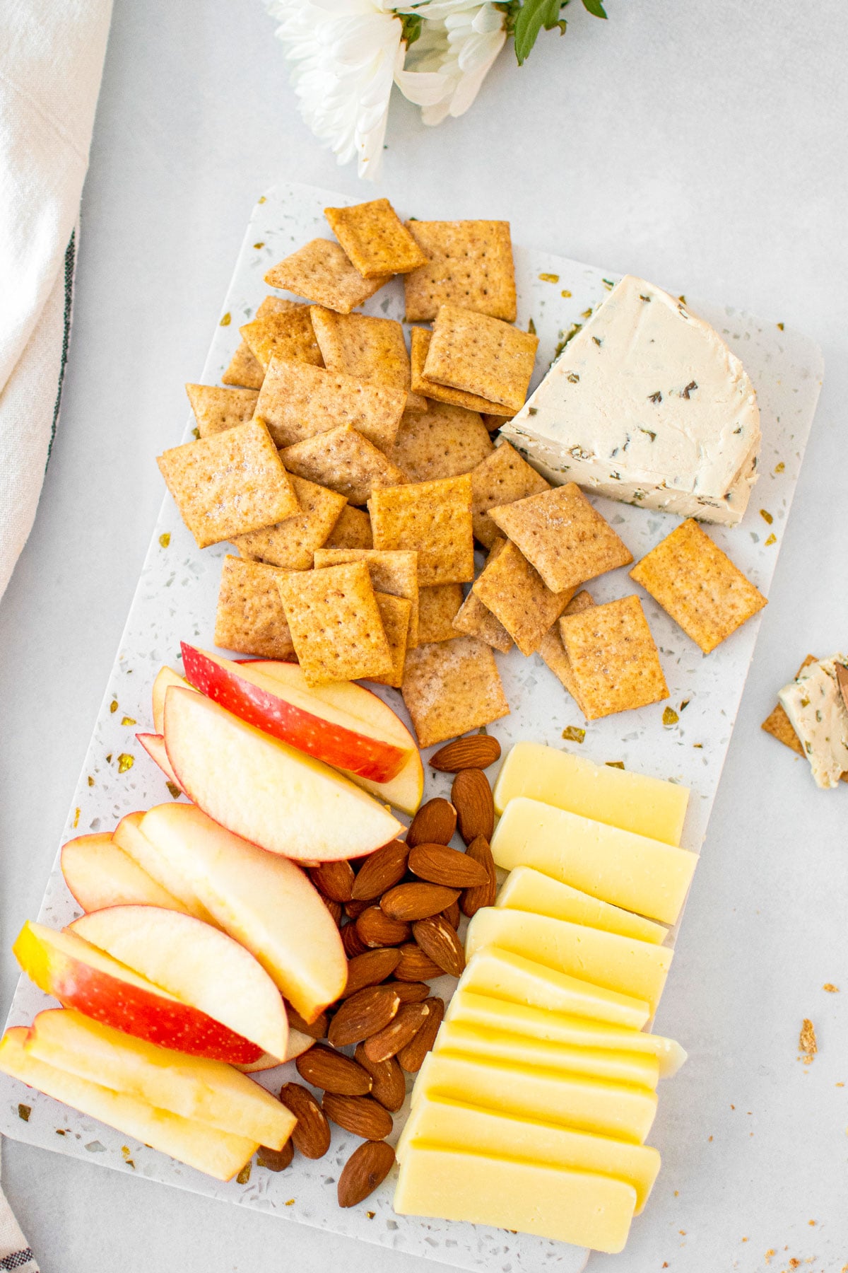 cheese board with homemade sourdough whole wheat crackers, apples, cheese and almonds.