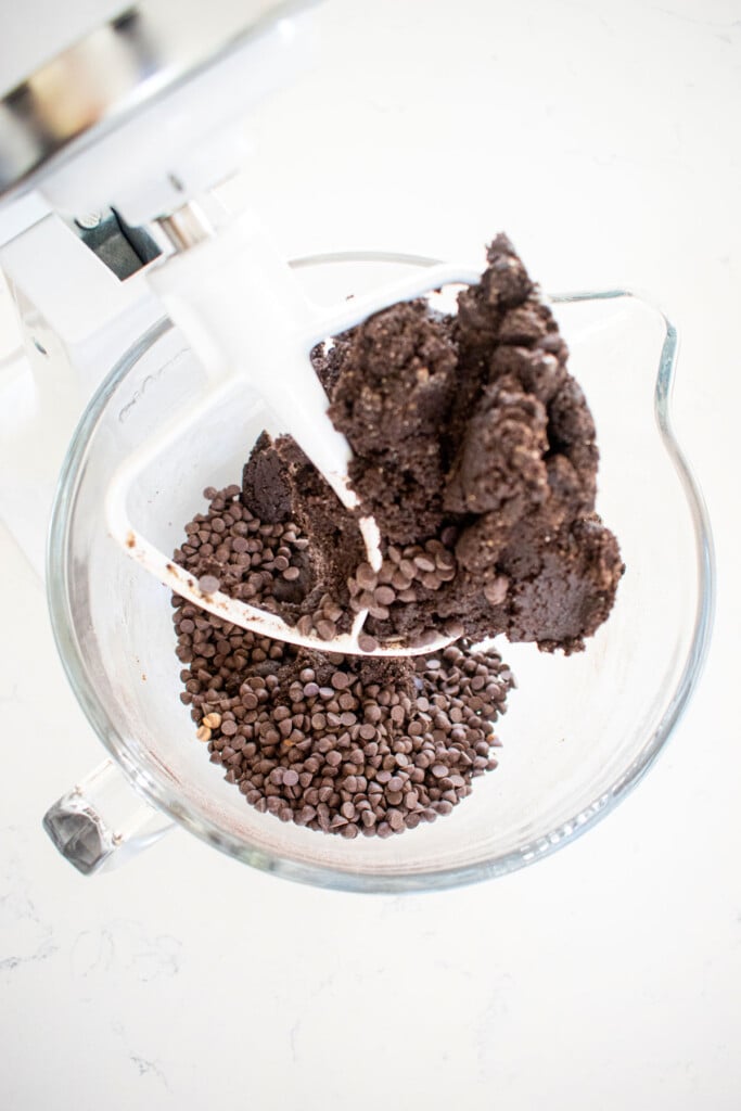 sea salt black cocoa biscotti cookie dough in a glass mixing bowl on a marble counter.