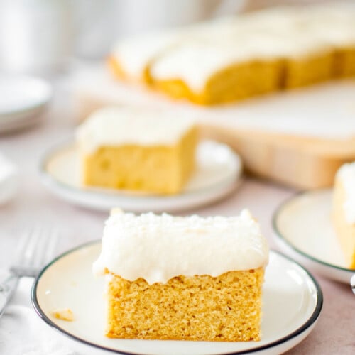 square slice of vanilla buttermilk sheet cake with vanilla frosting on a cake plate.