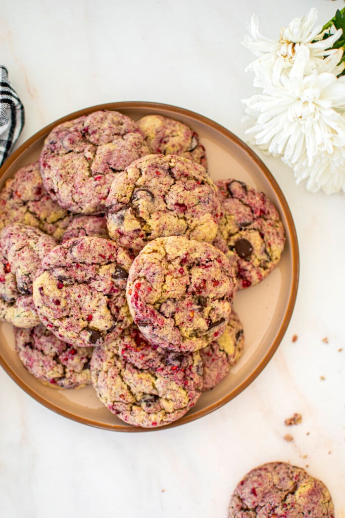 plate of vegan raspberry chocolate chip cookies on a marble table.