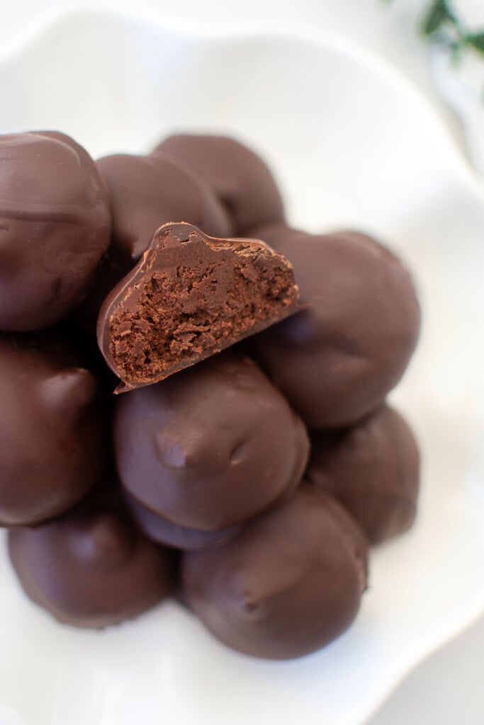 plate of chocolate cream drops on a white marble counter.