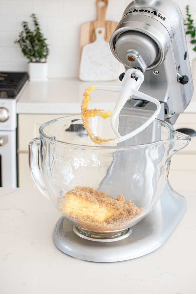 stand mixer on a marble kitchen counter with butter, sugar and vanilla.