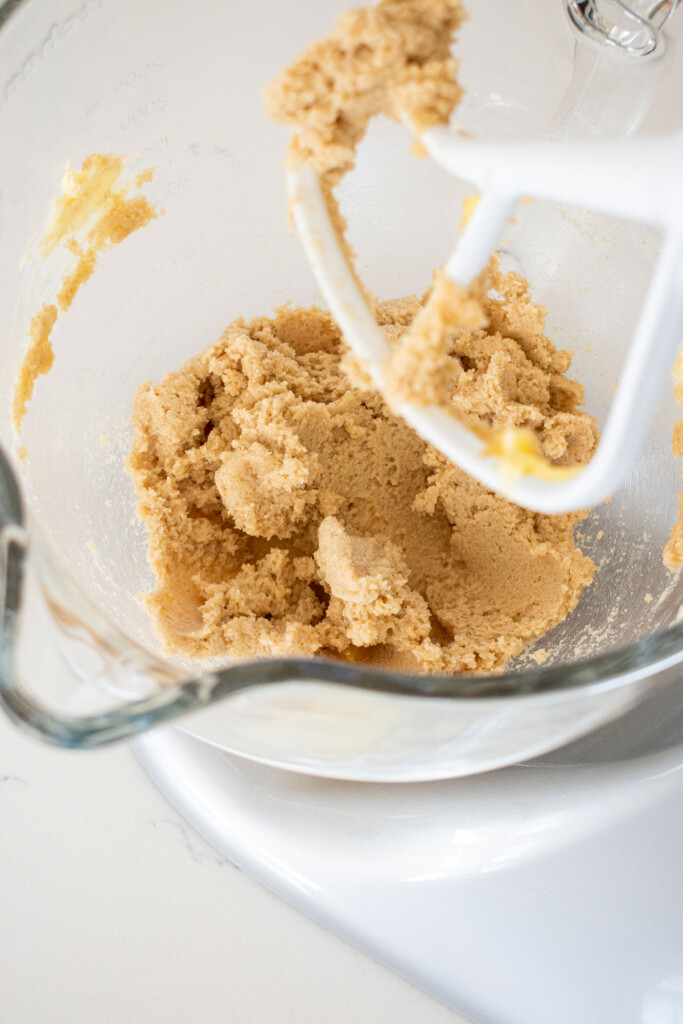 butter, sugar and vanilla creamed together in a stand mixer on a marble countertop.