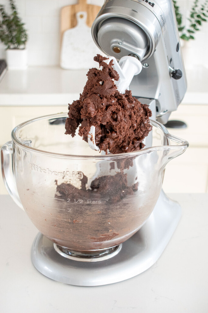 eggless chocolate chocolate chip cookie dough in a stand mixer on a marble kitchen countertop.
