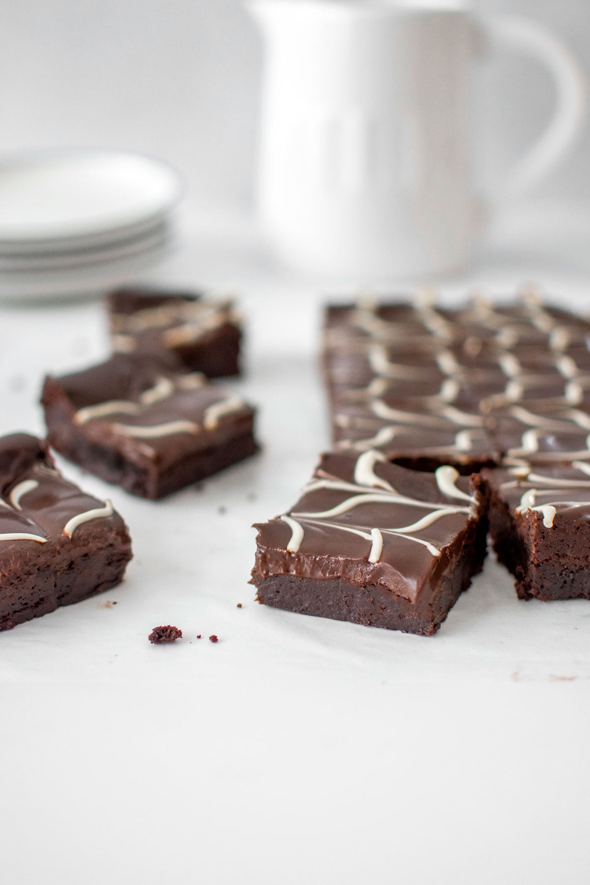 eggless chocolate ganache brownies cut into squares on a marble countertop.