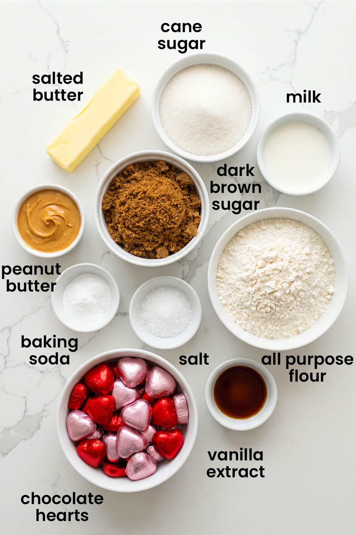 individual ingredients for eggless valentine's day peanut butter blossoms laid out against a white background.