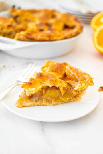 eggless orange blossom honey apple pie slice on a white plate.