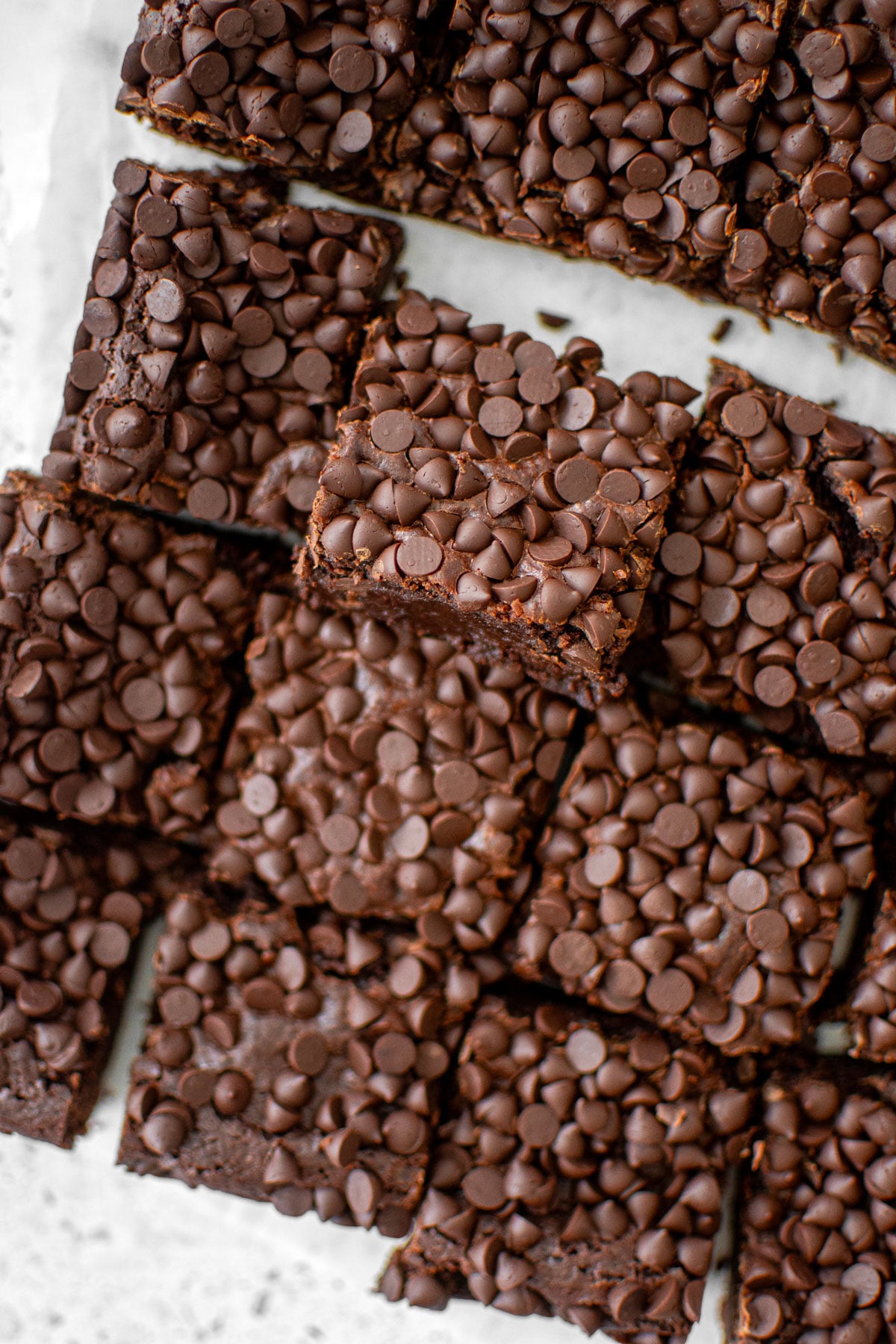 sourdough chocolate chip brownies cut into squares on a white counter.