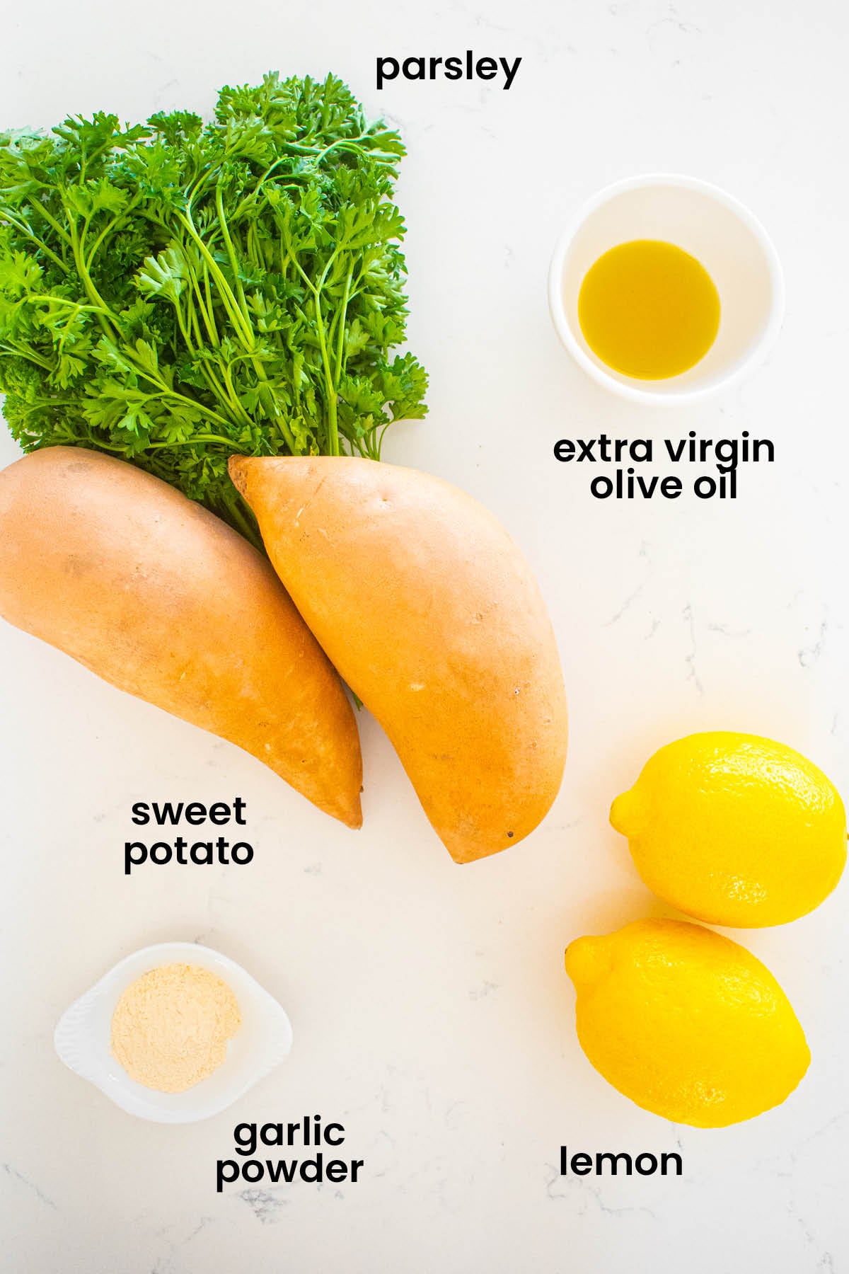 individual ingredients for garlic lemon sweet potato fries laid out against a white background.