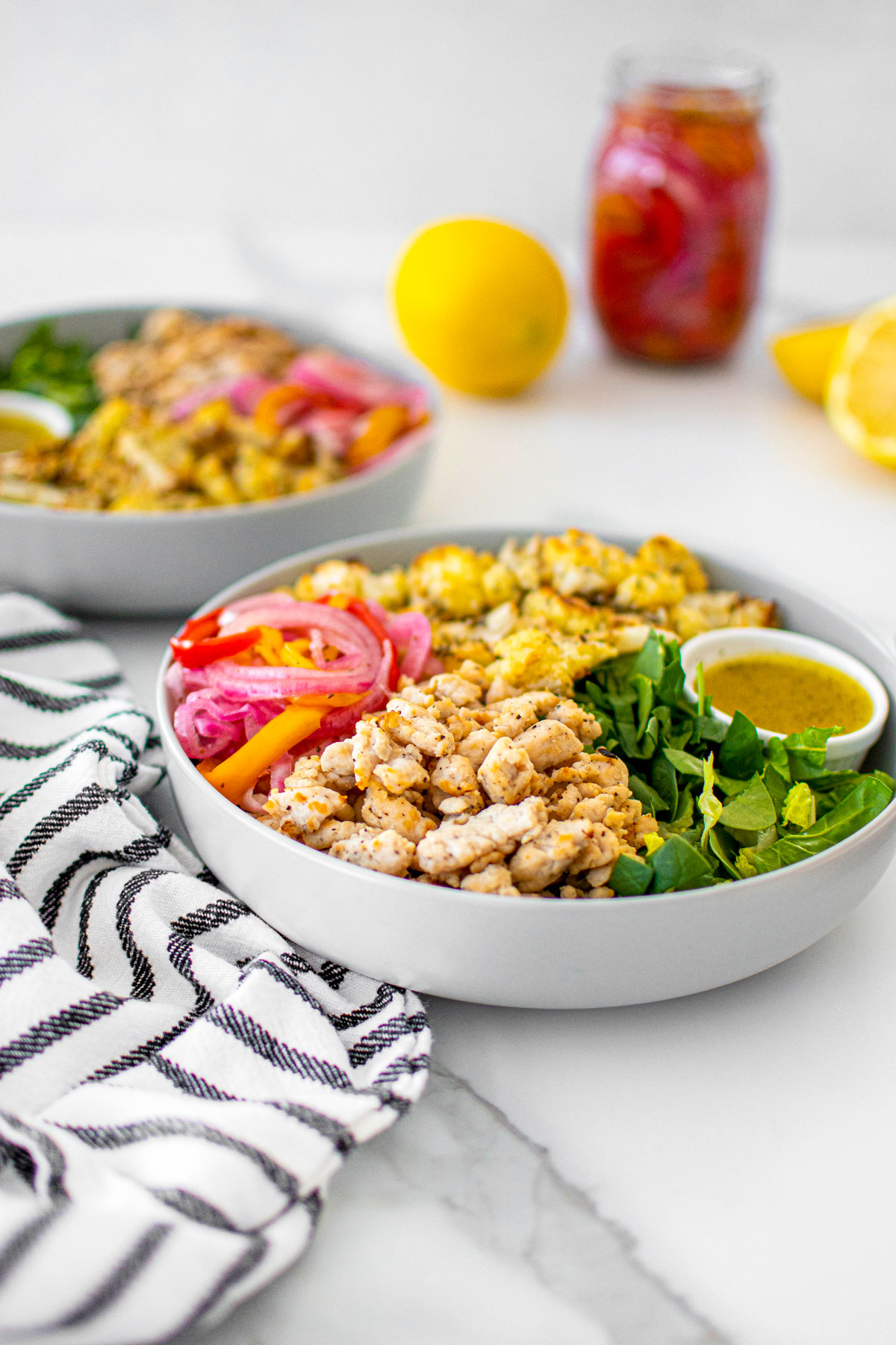 roasted cauliflower turkey salad with lemon dressing in a bowl on a white marble countertop.