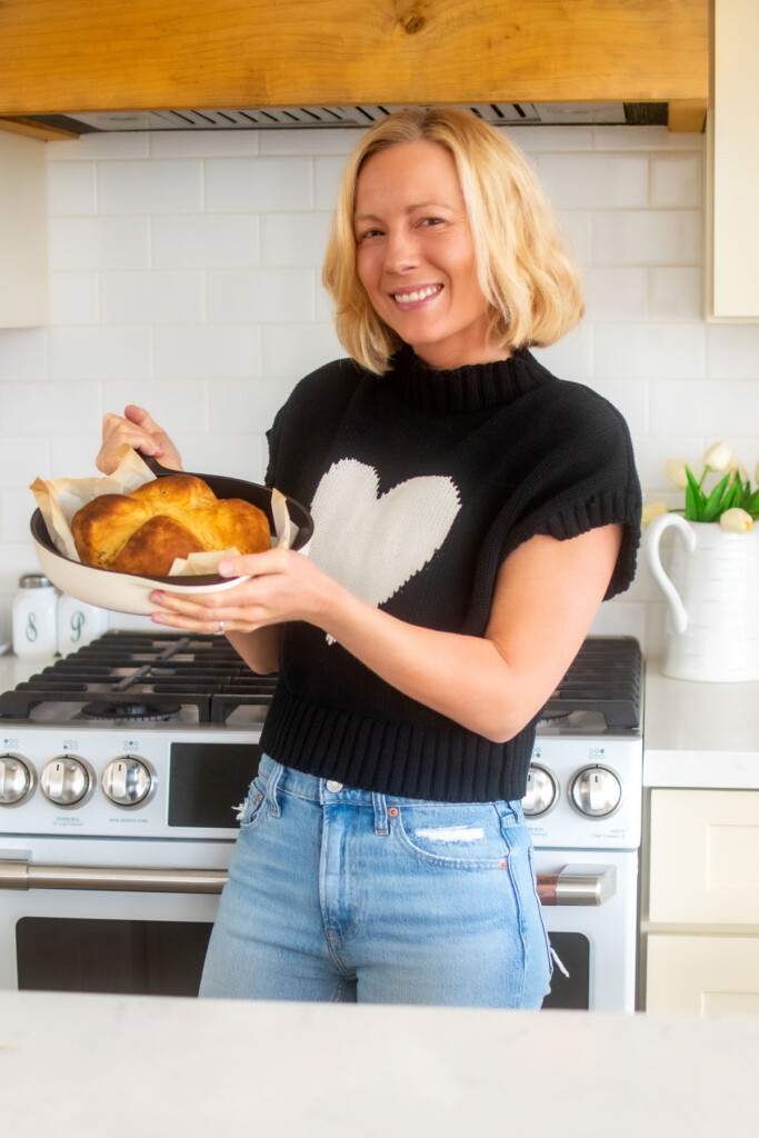 woman holding cast iron skillet with irish soda bread in the kitchen.
