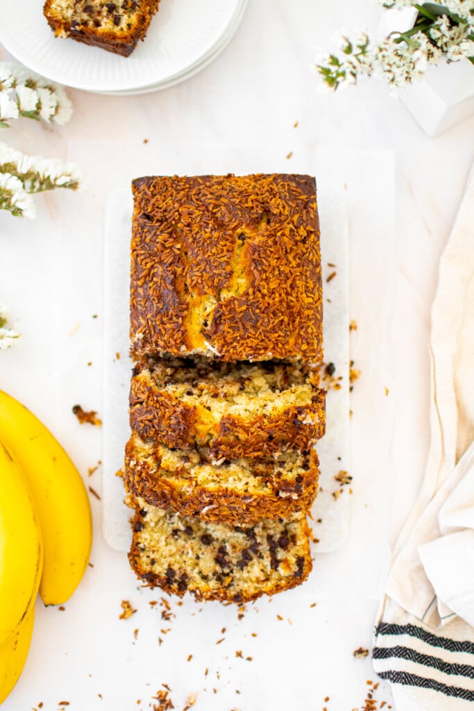 coconut chocolate chip banana bread loaf cut into slices.