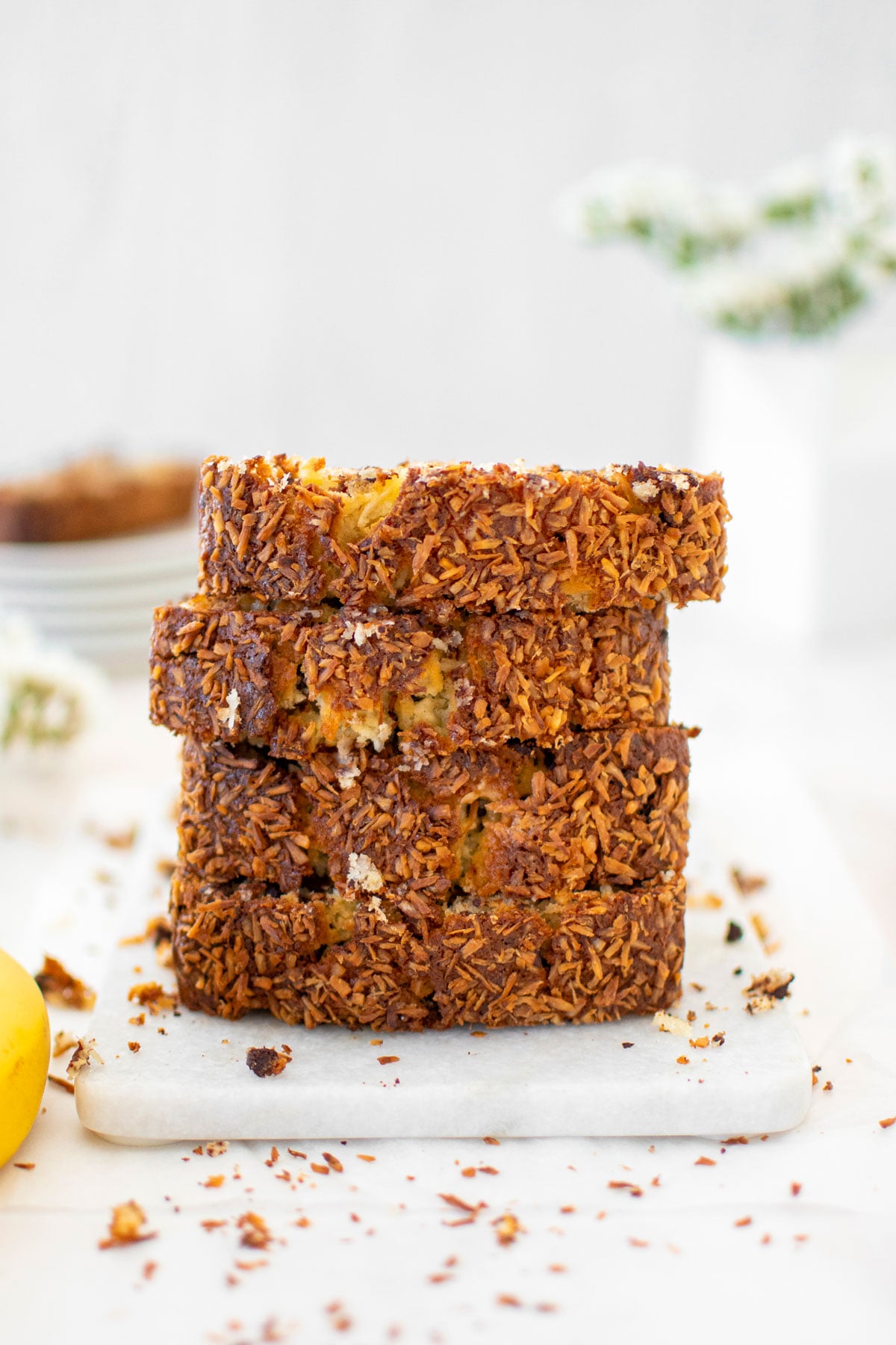 stack of coconut chocolate chip banana bread slices on a white marble board.