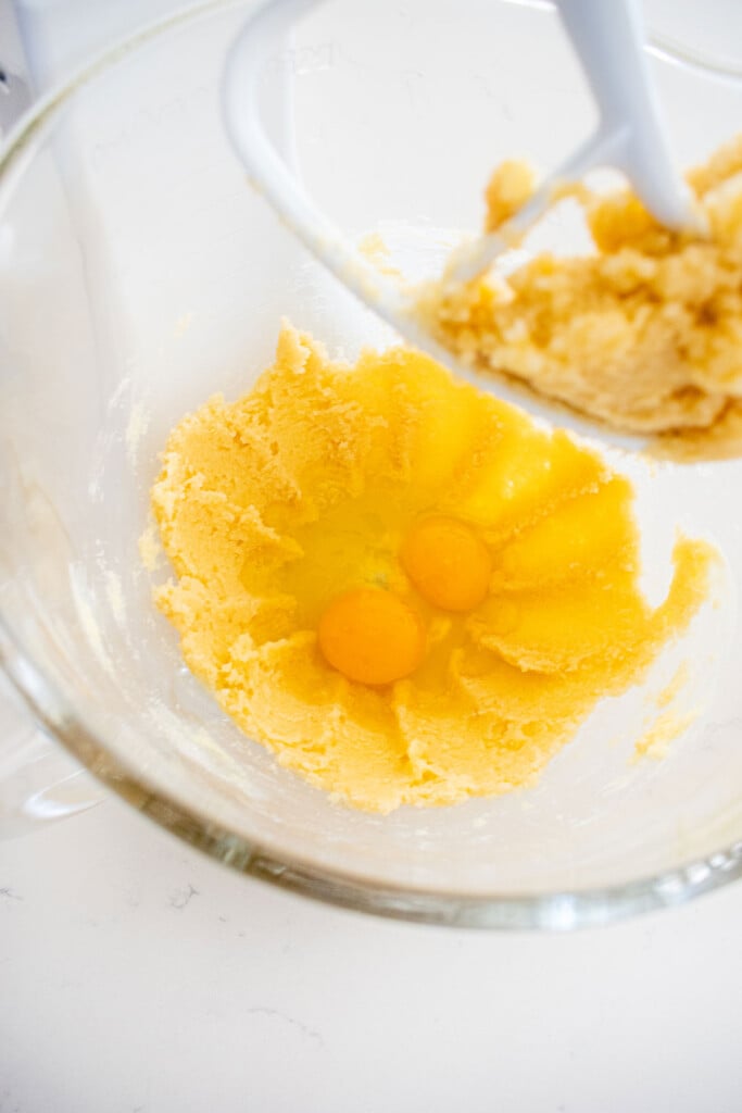 creamed butter and sugar in a glass mixing bowl with eggs.