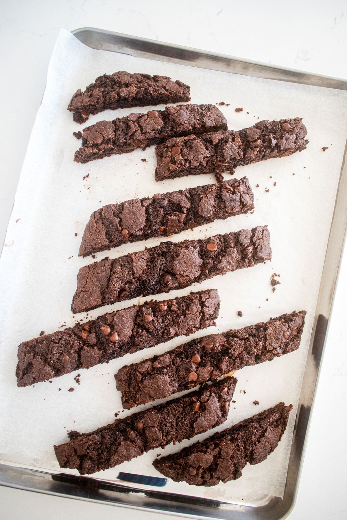 chocolate espresso cut into pieces on a baking sheet on a marble counter.