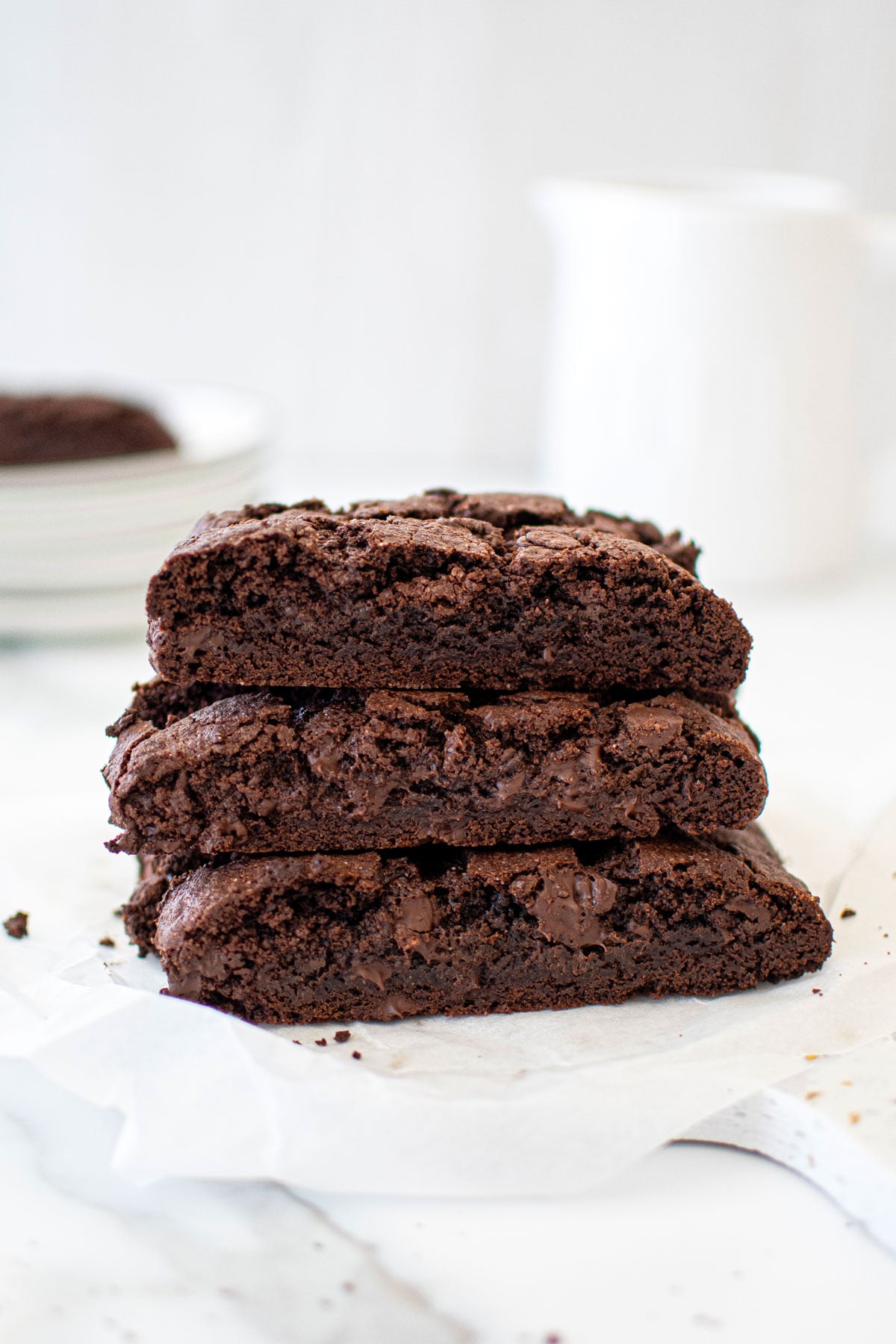 chocolate espresso biscotti stacked on a marble board on a marble table.