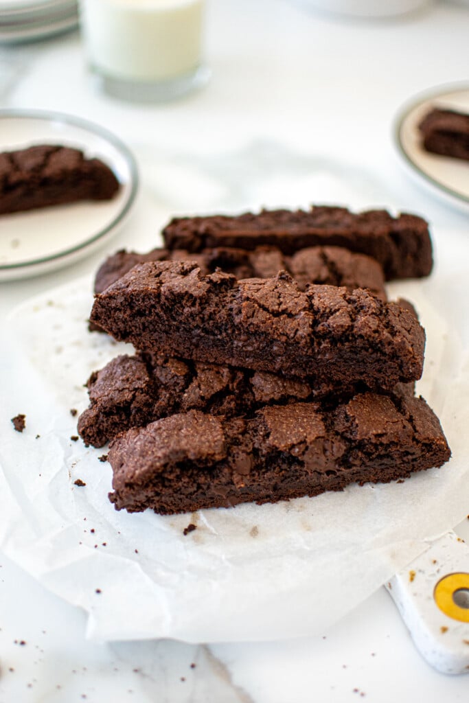 chocolate espresso biscotti stacked on a marble board on a marble table.