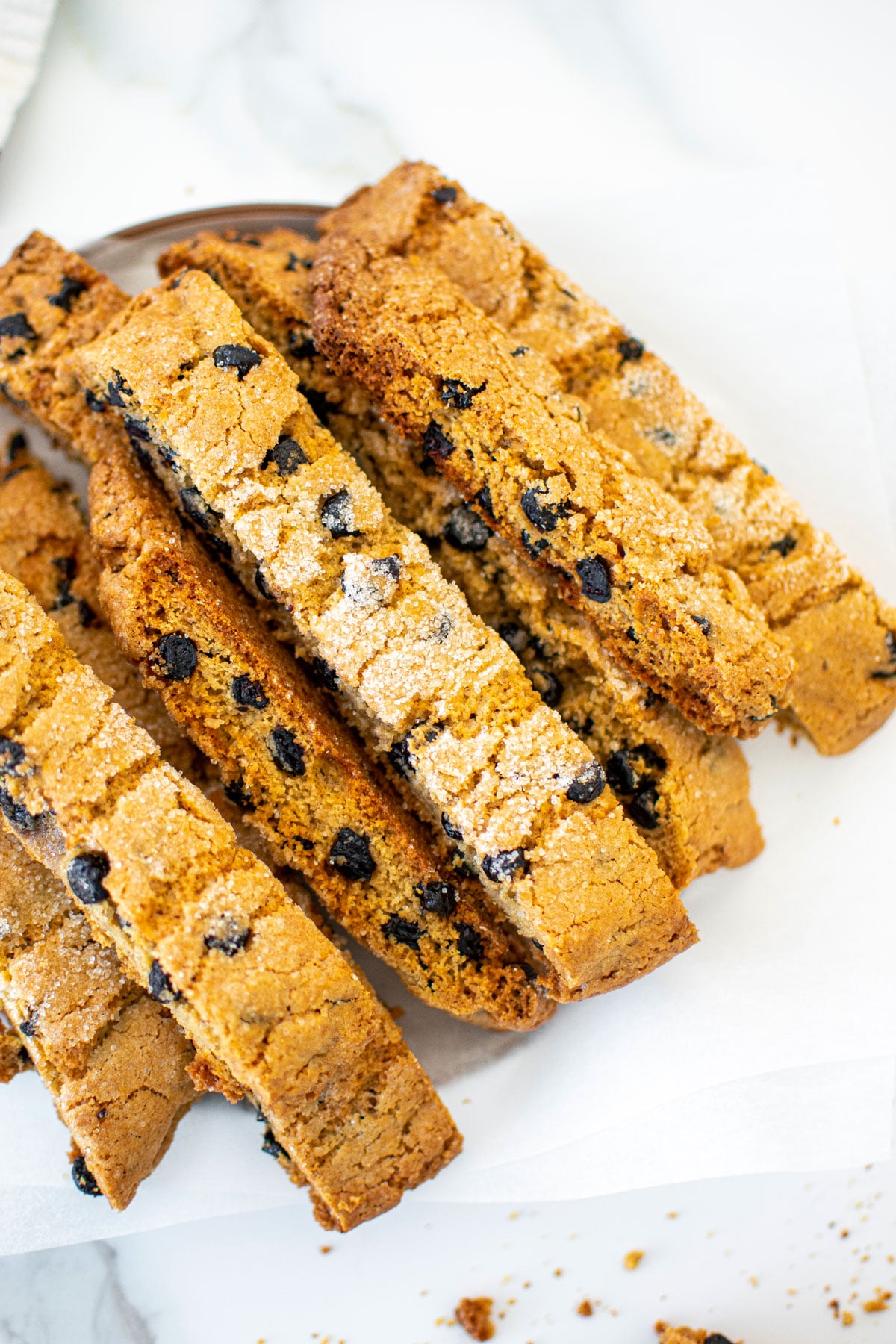 blueberry muffin biscotti on a plate on a marble counter.
