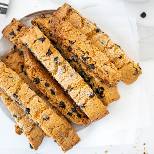 blueberry muffin biscotti on a plate on a marble counter.
