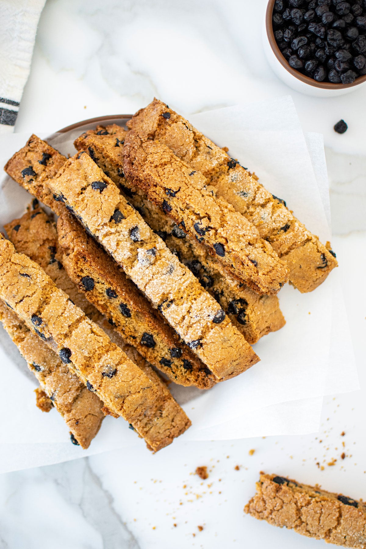 blueberry muffin biscotti on a plate on a marble counter.