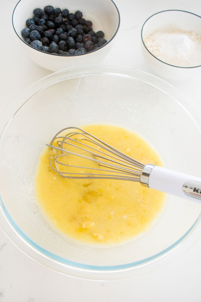 blueberry pancakes for dogs batter being mixed in a mixing bowl on the counter.