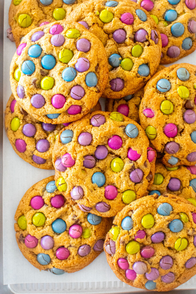 baking sheet of naturally colored M&M cookies on a white marble counter.