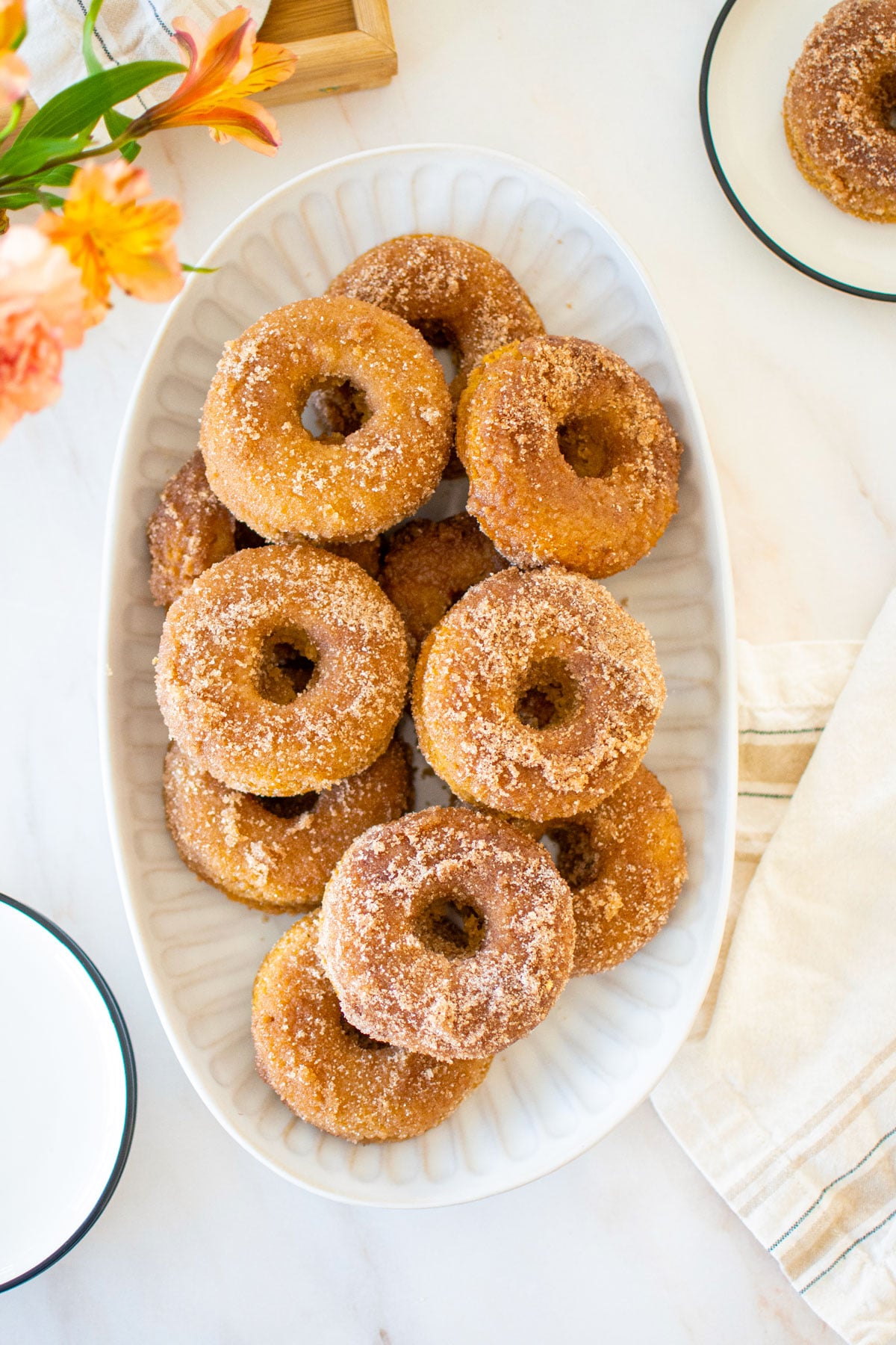 snickerdoodle banana baked donuts on a platter on a marble countertop.